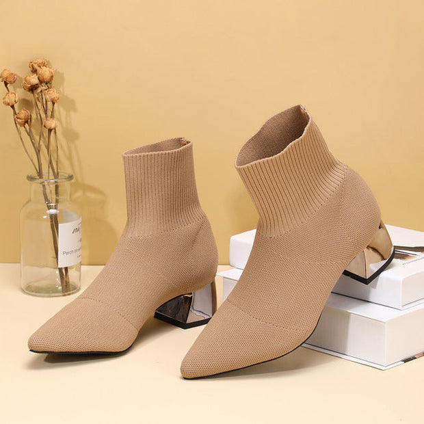 Apricot knitted boots on books with decor