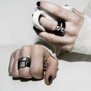 Person wearing multiple rings, including silver square detail ring